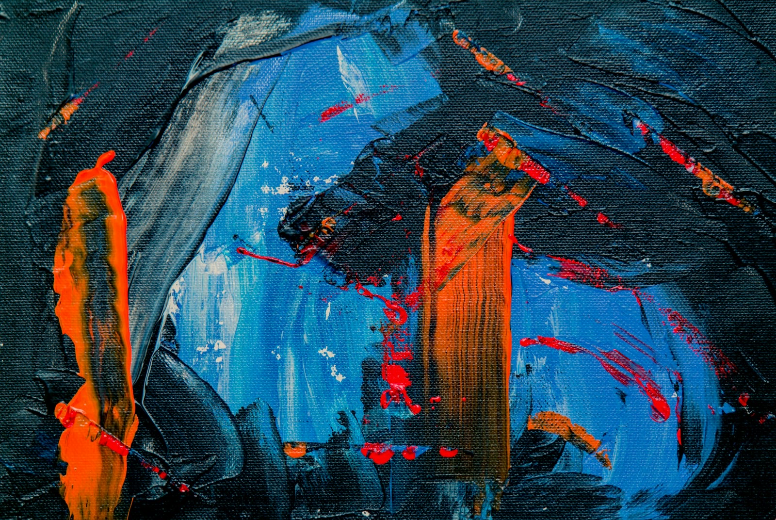 Detail of an abstract painting in blue, black, and orange oils