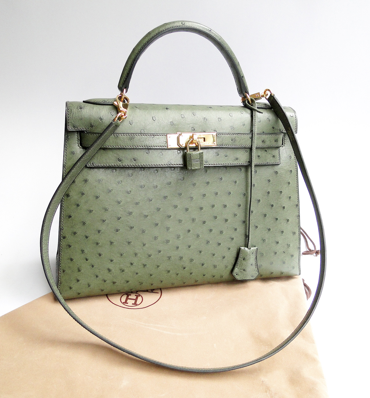 Green ostrich-leather Herm&egrave;s Kelly bag with gold hardware, padlock and clochette on its dust bag
