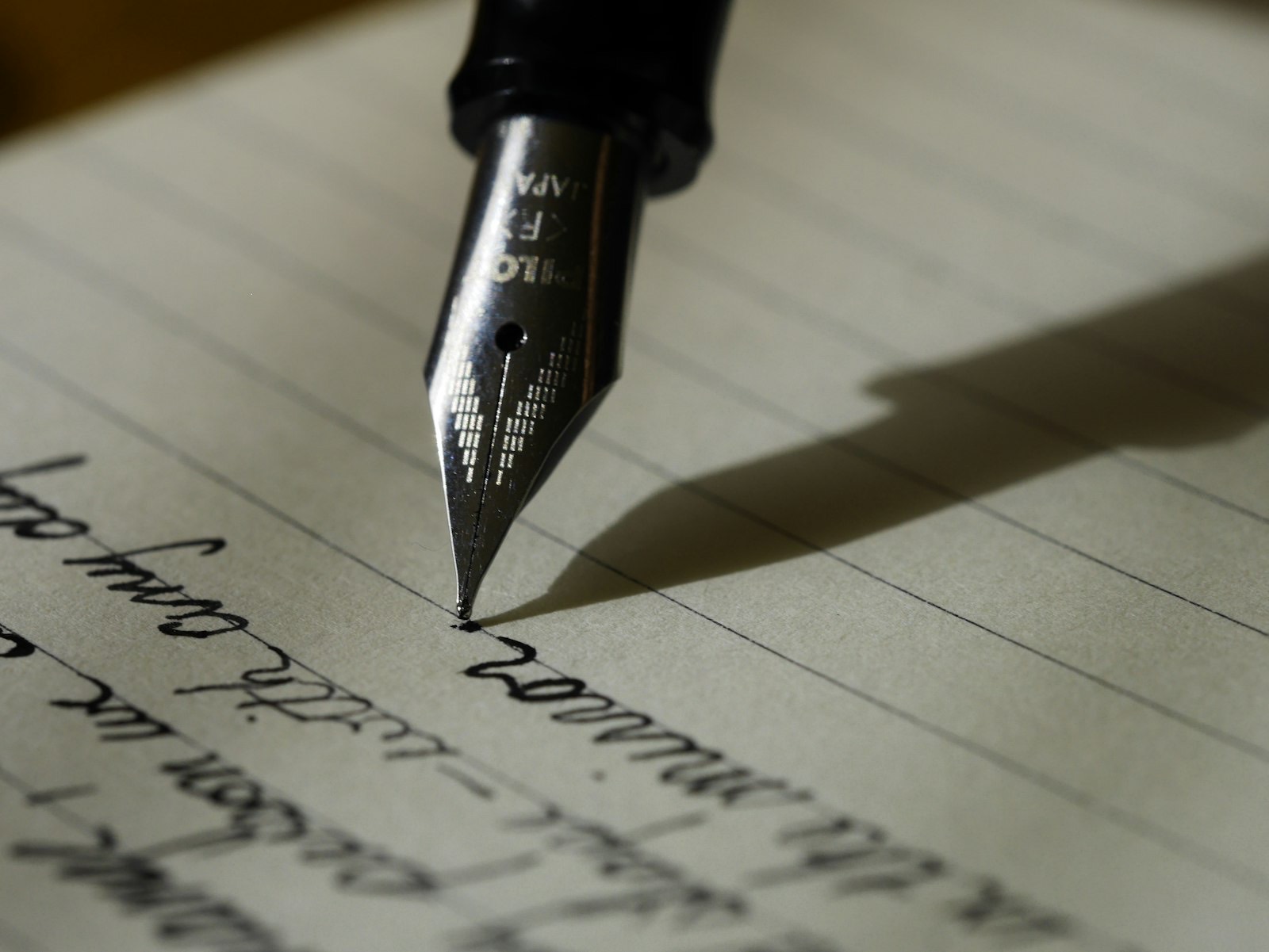 Fountain pen nib writing on lined paper