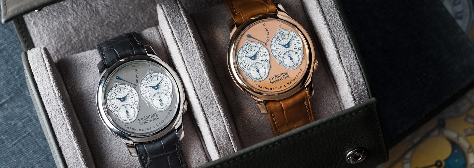 Two F.P. Journe Chronomètre à Résonance watches, in platinum and in rose gold, resting in a leather travel case