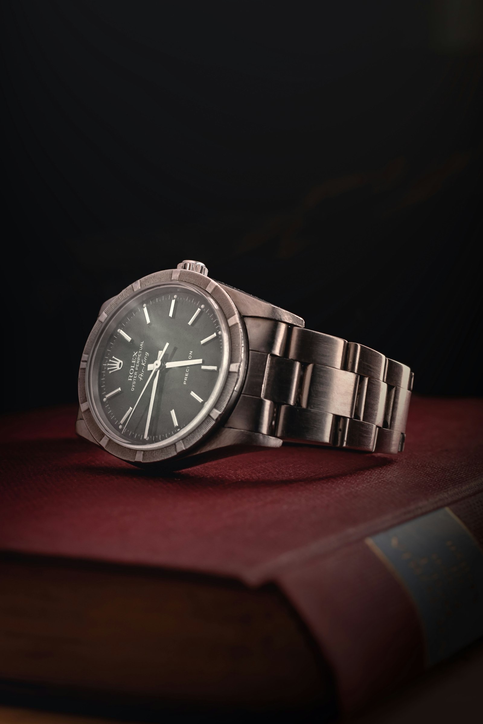 Stainless steel Rolex resting on a leather-bound book